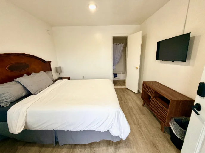 Room with one large bed and a wall-mounted TV